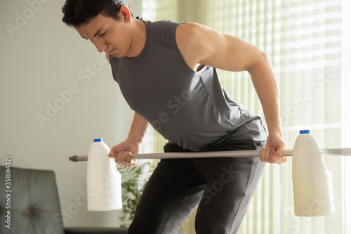 person in confinement practicing rowing exercises with homemade elements