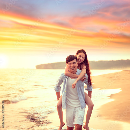 happy young Man Giving Woman Piggyback On Summer Beach