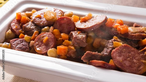 South American cuisine: Puchero soup with sausage. close-up in a pot on the table with smoke. photo