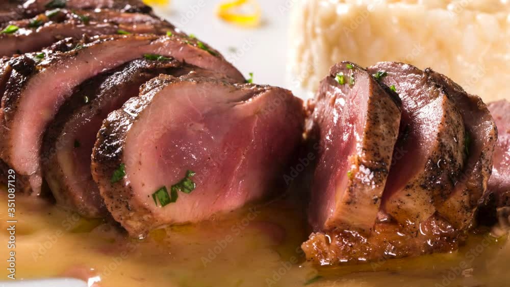 Duck magret with tucupi sauce and jambu risotto. Front view with smoke.