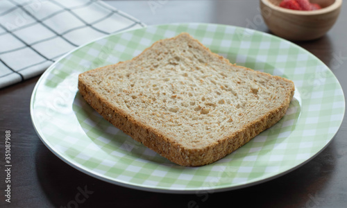 whole wheat bread in plate on wooden table for breakfast meal