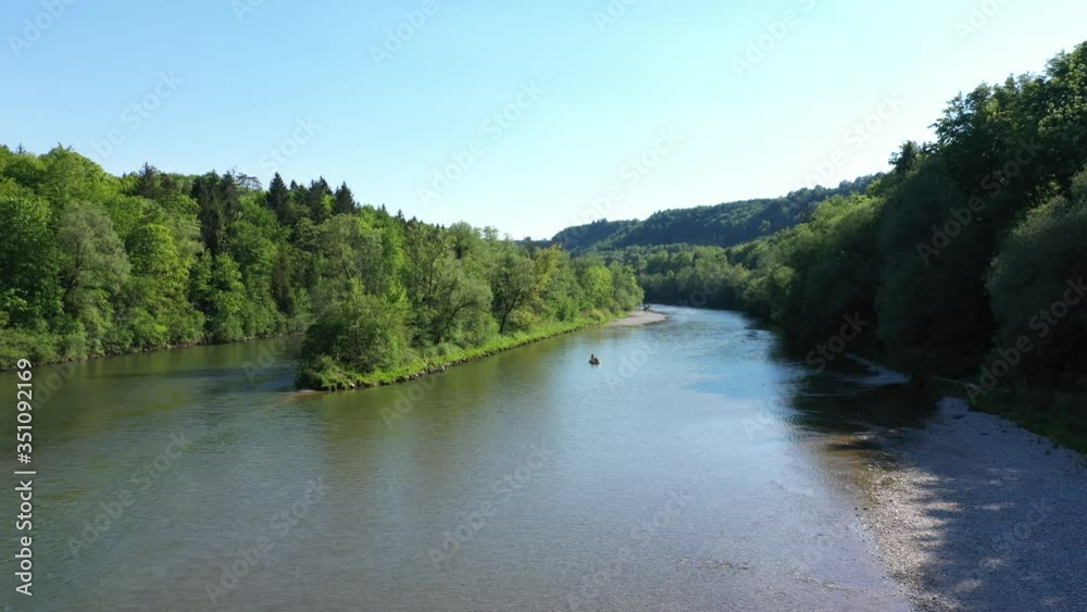 Drone video of German river near the Alps with people paddling on a boat. Aerial view of Isar river and boat. Drone video of German river near the Alps with people paddling on a boat. Aerial view of Isar river and boat.