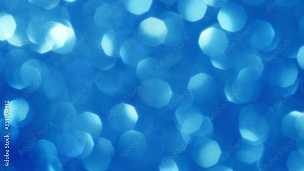 Abstract background with shining blue bokeh sparkles. Glittering Particles. Defocused circular facula. Natural Floating Organic Abstract Background. Christmas and Happy new year.