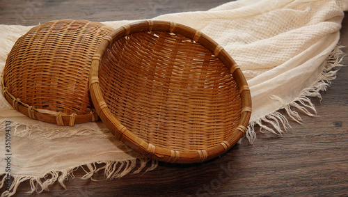 White fabric and the bamaoo basket on the wooden table.