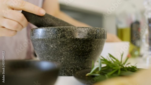 Wallpaper Mural Home cook mixing coriander seeds in a pestle mortar and pouring the coriander powder into a black bowl. Side view, macro lens 4K pro res Torontodigital.ca
