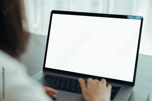 Woman had using laptop white screen and stationery on the table.