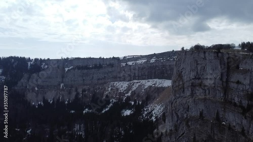 Drone view to the famous rock wall of CreuxDuVan, with clouds, snow and trees photo