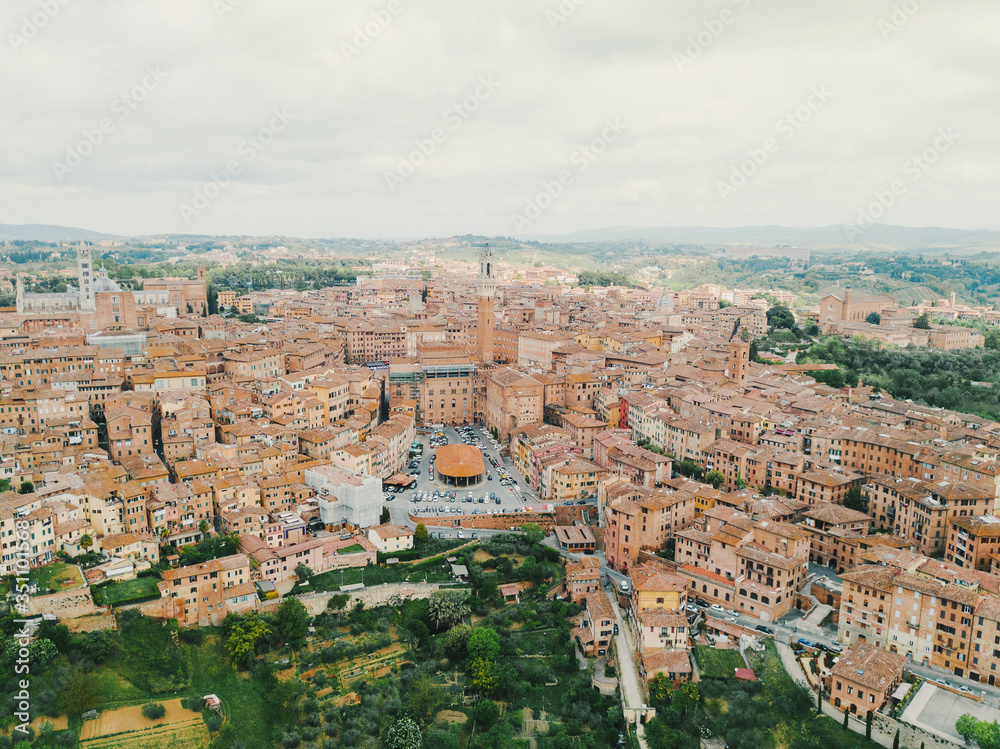 Panoramic aerial shot of Siena, cityscape, a beautiful medieval town in Tuscany, with view of the Dome Bell Tower of Siena Cathedral, landmark Mangia Tower and Basilica of San Domenico, Italy