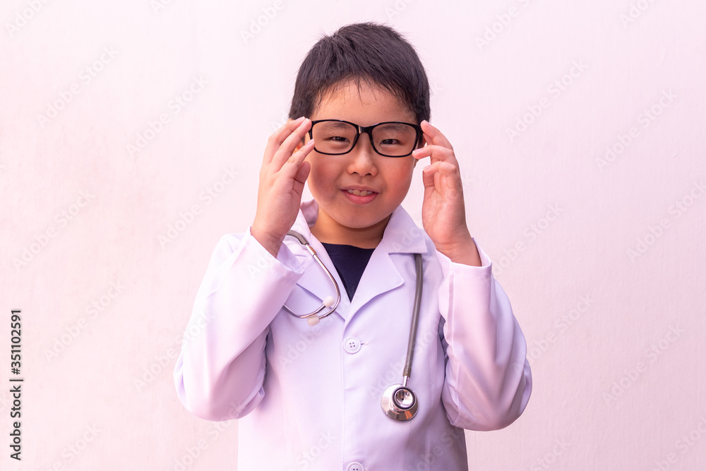 Asian boy playing doctor with stethoscope in hands. Asian boy playing doctor with stethoscope in hands.