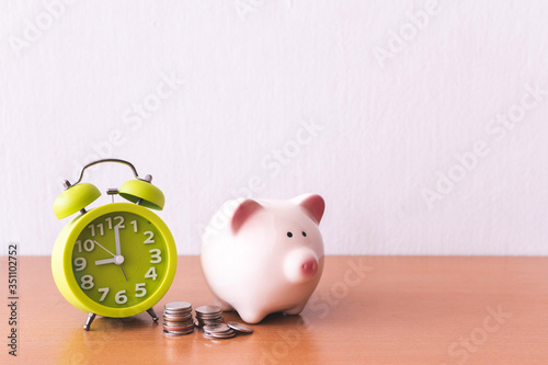 Piggy bank, alarm clock and coins. for growing business. time to saving concept.