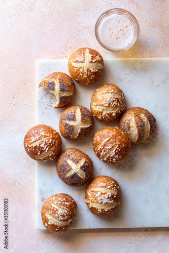 Soft pretzel buns and a glass of beer on the table photo