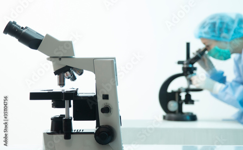 female doctor analyzing virus and light microscope close-up
