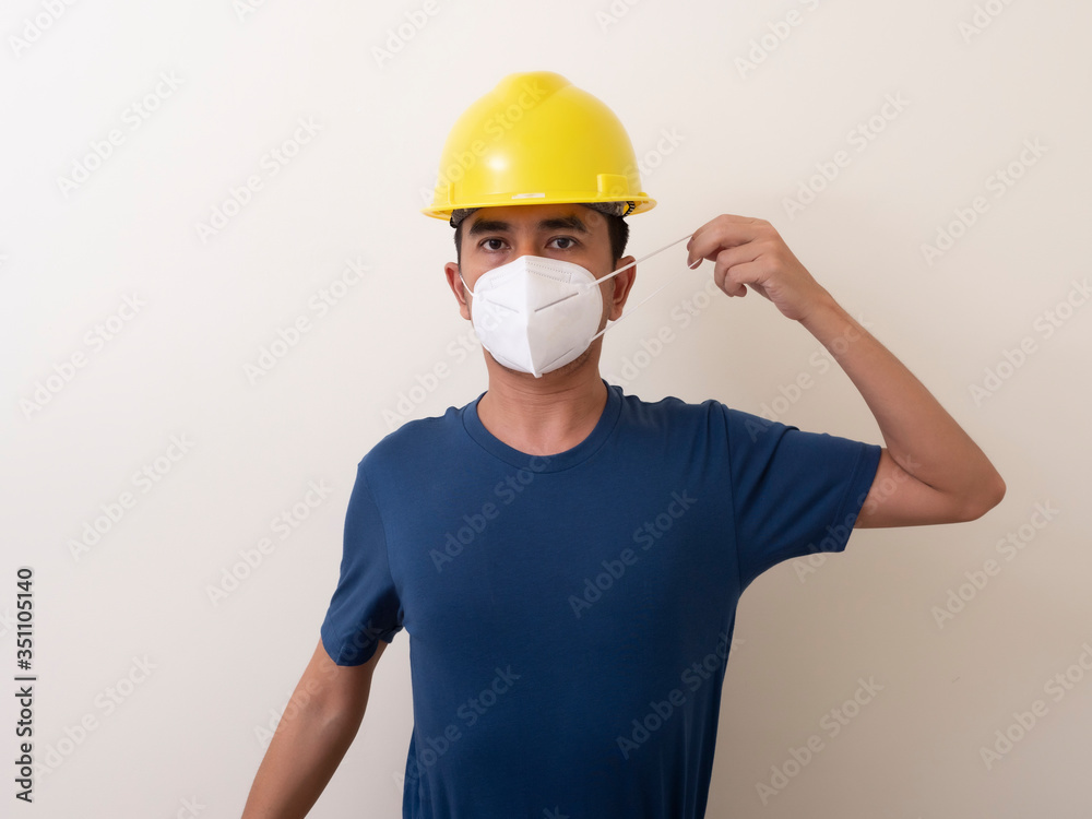 Asian industrial workers wear yellow hard hats, wear protective masks for their health Asian industrial workers wear yellow hard hats, wear protective masks for their health
