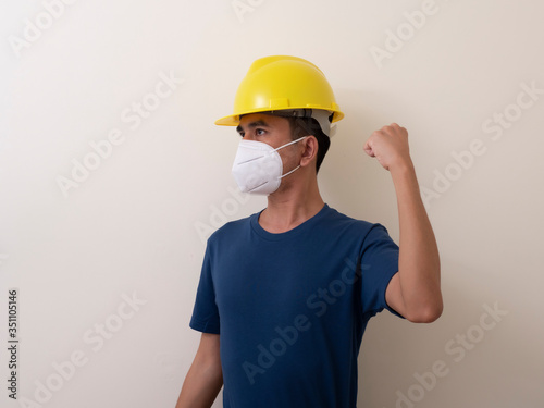 Asian industrial workers wear yellow hard hats, wear protective masks for their healtha photo