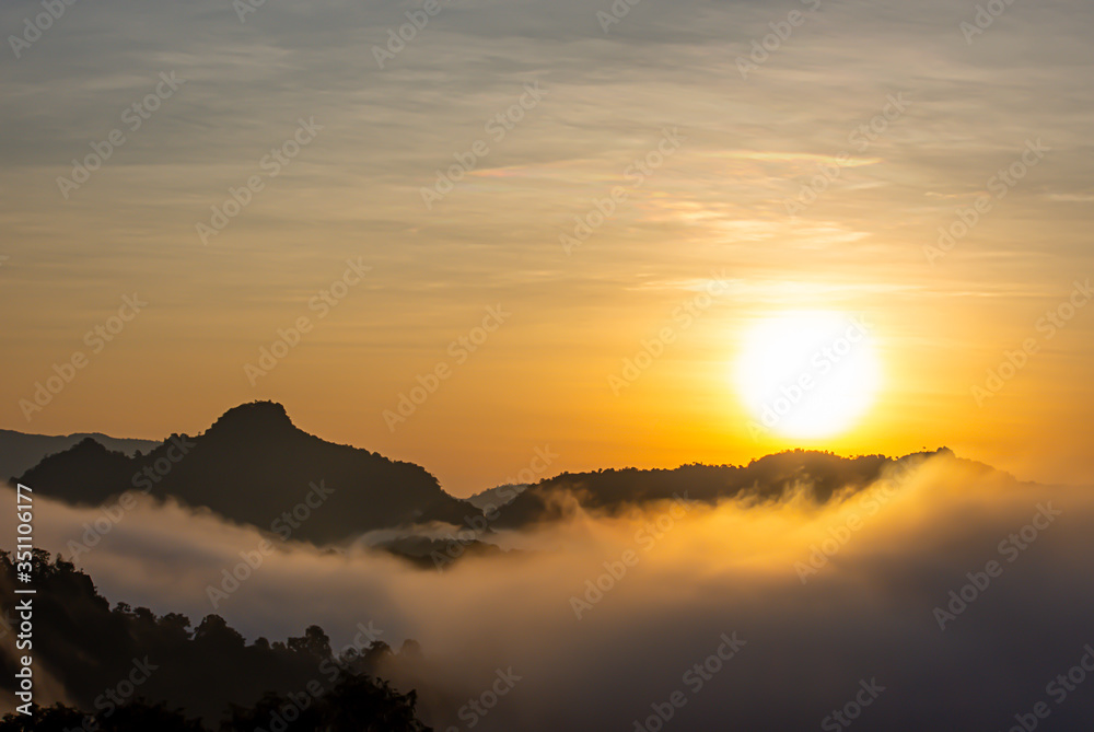 Sunrise and morning light behind the mountains with the mist covered.