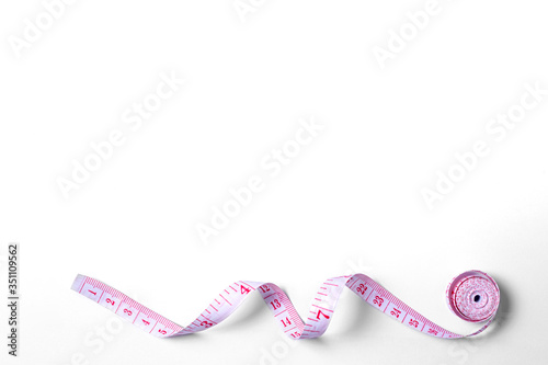 Pink measuring tape isolated on white background. Top view