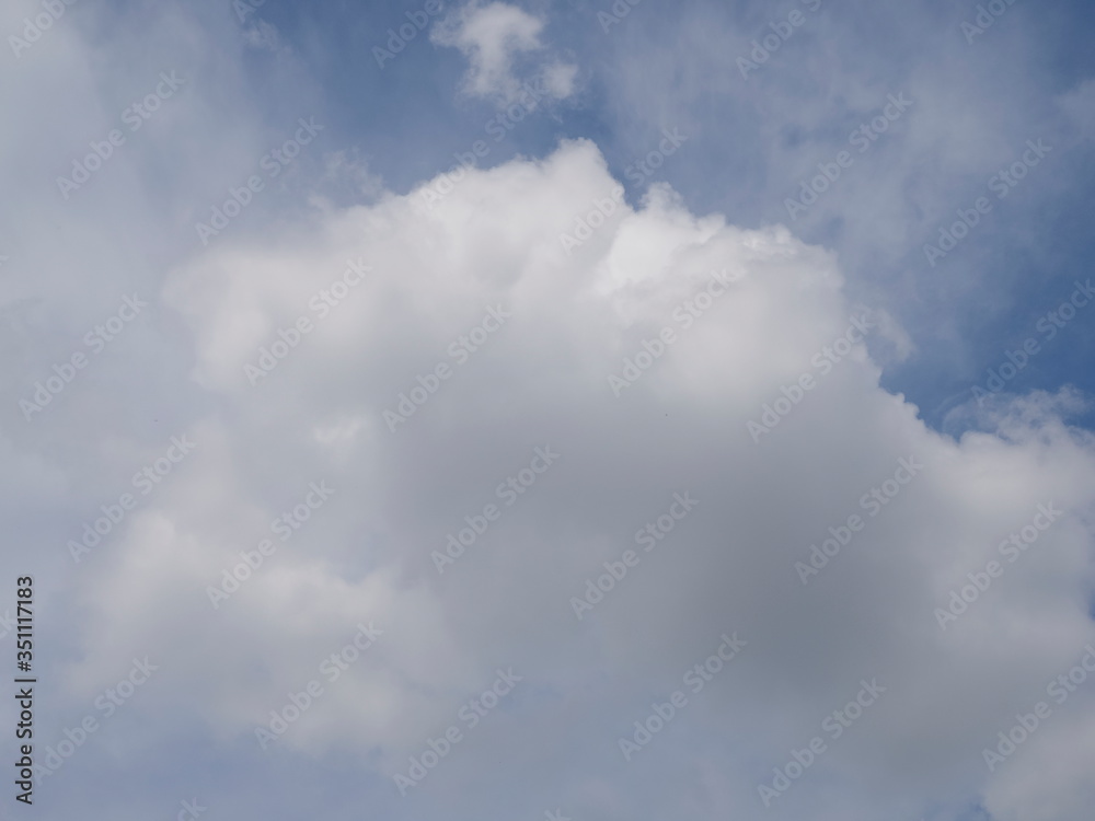 Ant's eye view of white clouds moving with blue sky background.