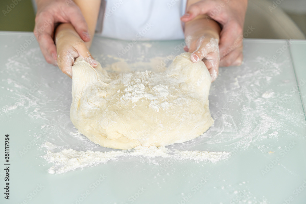 hands of a child and dad cook from dough hands of a child and dad cook from dough