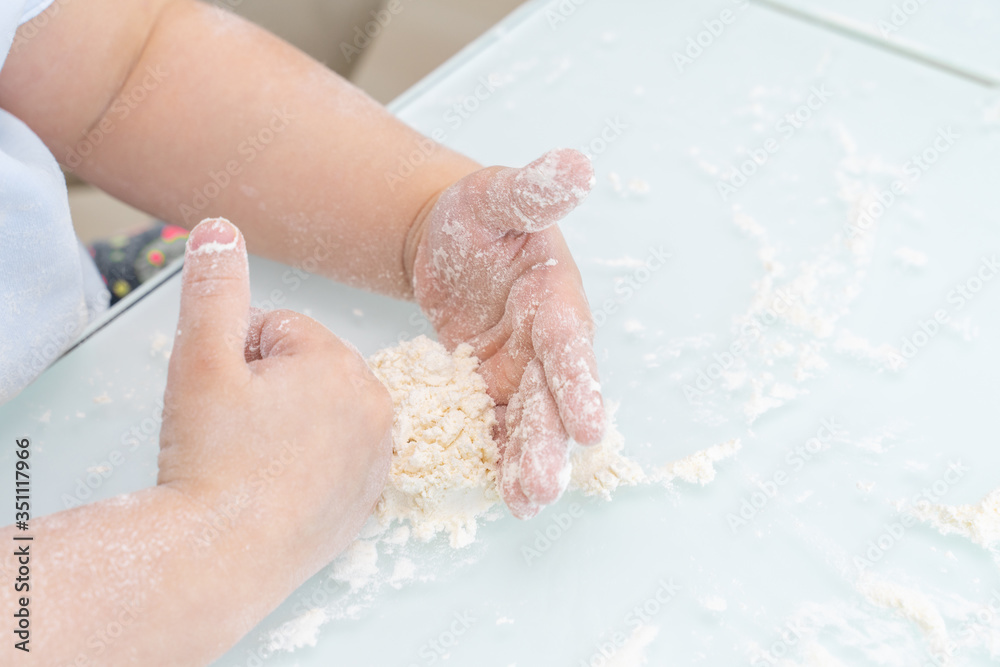 Fototapeta premium child plays with flour on the table