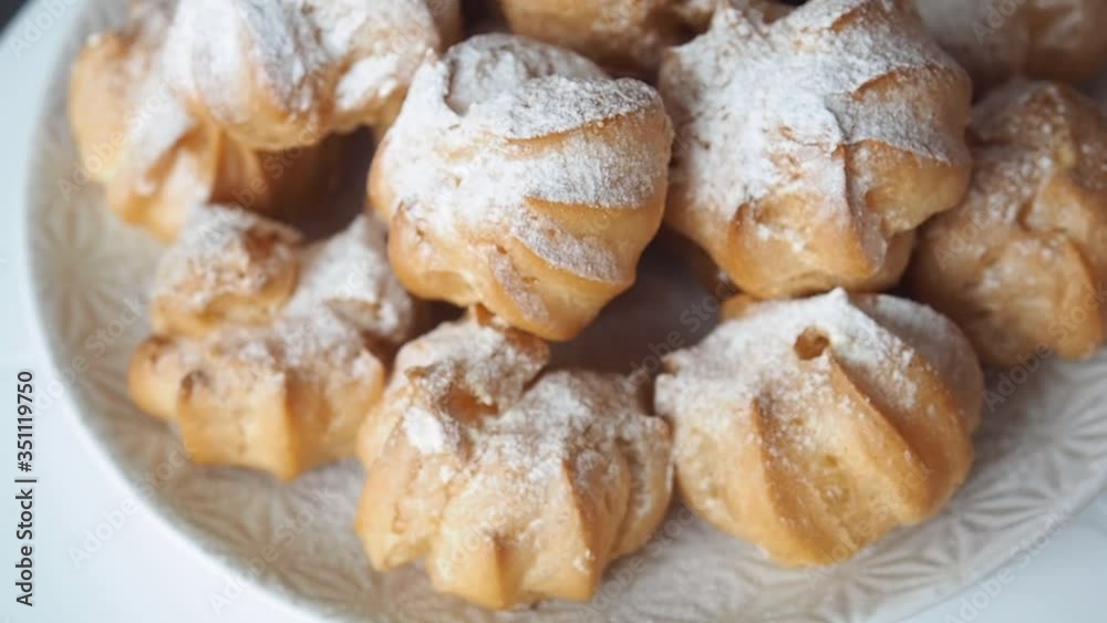 Profiteroles with custard cakes rotate. Close up. Profiteroles with custard cakes rotate. Close up.