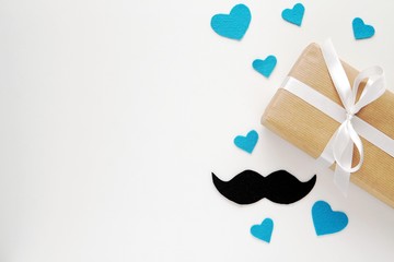 Happy fathers day background with gift box, handmade felt fabric mustache and hearts, love dad concept, copy space.