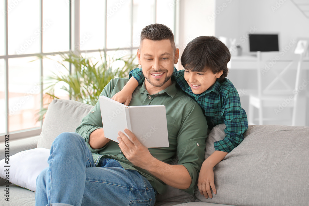 Father and little son reading book at home Father and little son reading book at home