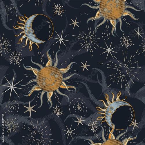 Sun, moon and stars on a dark, grey blue sky, imitation of embroidery on fabric. Seamless vector illustration with starry sky. A square repeating design on the subject of astrology