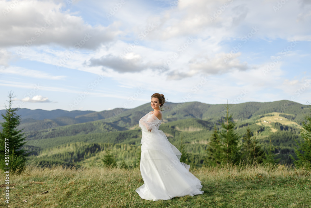 The bride herself poses on a background of mountains. The bride herself poses on a background of mountains.