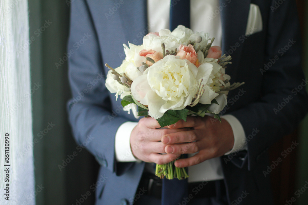 Wedding bouquet of flowers in the hands of the groom in a suit. Wedding bouquet of flowers in the hands of the groom in a suit.