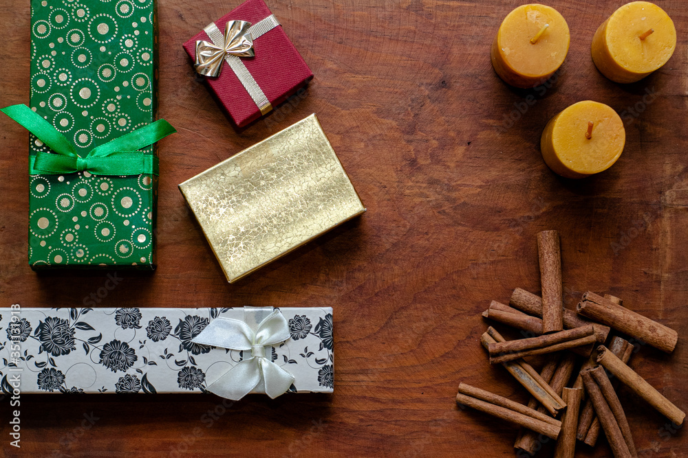 Regalos con velas y canela en fondo de madera Regalos con velas y canela en fondo de madera
