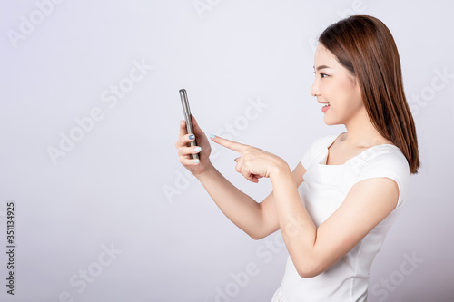 Asian pretty woman touch her mobile phone. Telling, shopping promotion, announcement and successful concept.
