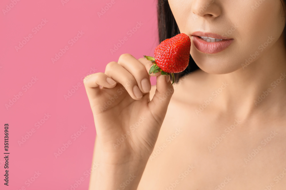 Sexy young woman with strawberry on color background, closeup