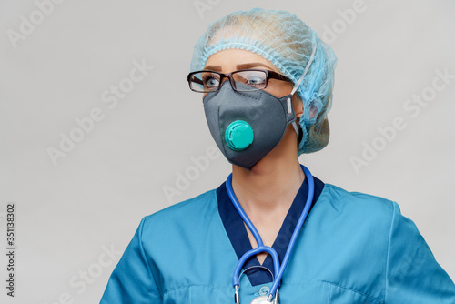 female doctor with stethoscope wearing protective mask and latex gloves over light grey background