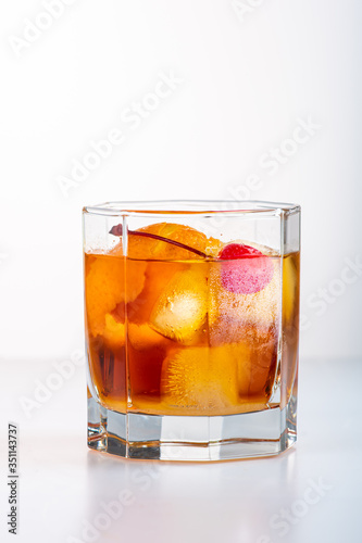 old fashion cocktail in a glass of rox on a white background