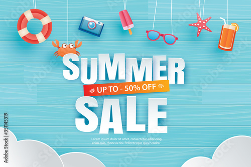 Summer sale with decoration origami hanging on blue wooden background. Paper art and craft style.