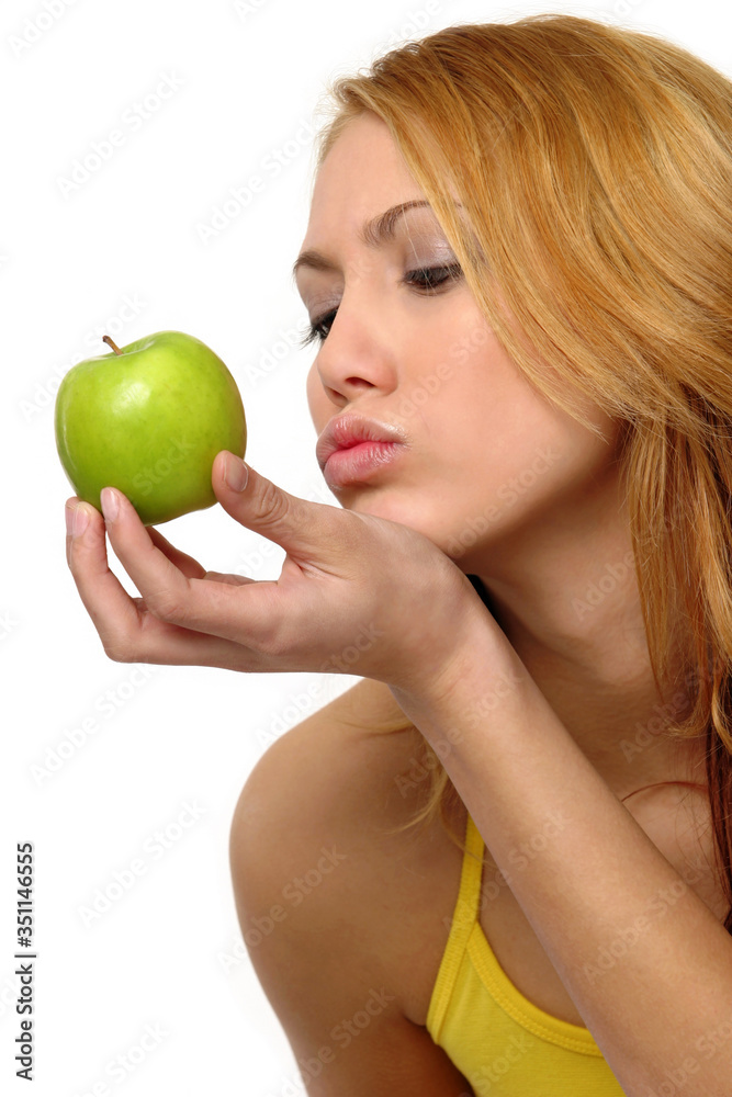 A woman trying to kiss a green apple A woman trying to kiss a green apple