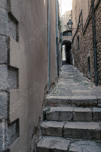 Girona's landmark narrow streets with cobble stone and stairs on a long outdoor corridor and nobody on it