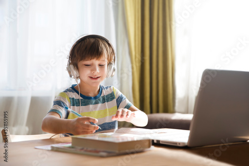 child boy is using a laptop and study online at home. homeschooling, distant learning