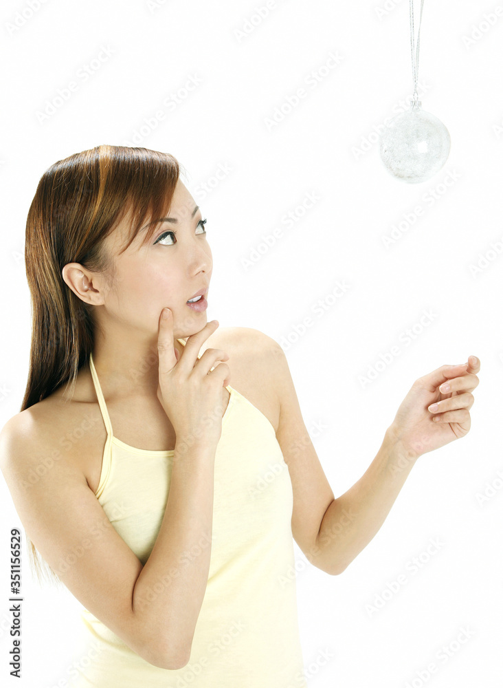 Woman looking at hanging Christmas ornament Woman looking at hanging Christmas ornament