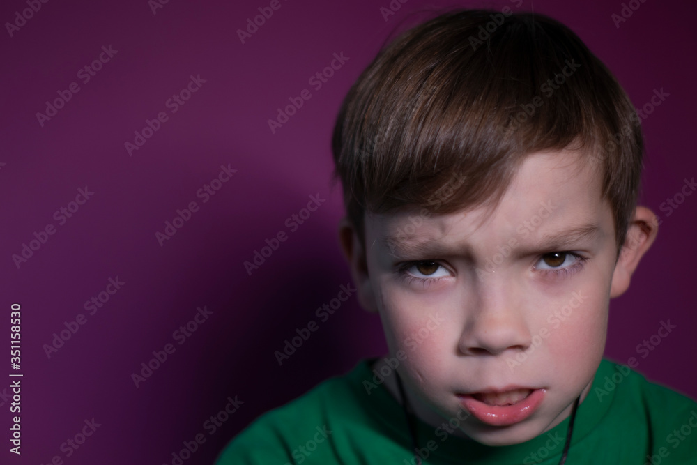 portrait of a pensive angry nine year old blond boy on a pink background - horizontal photo portrait of a pensive angry nine year old blond boy on a pink background - horizontal photo