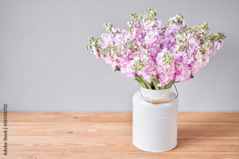 Bouquet of Beautiful lilac mattiola. Spring flowers in vase on wooden table. Flowers delivery.