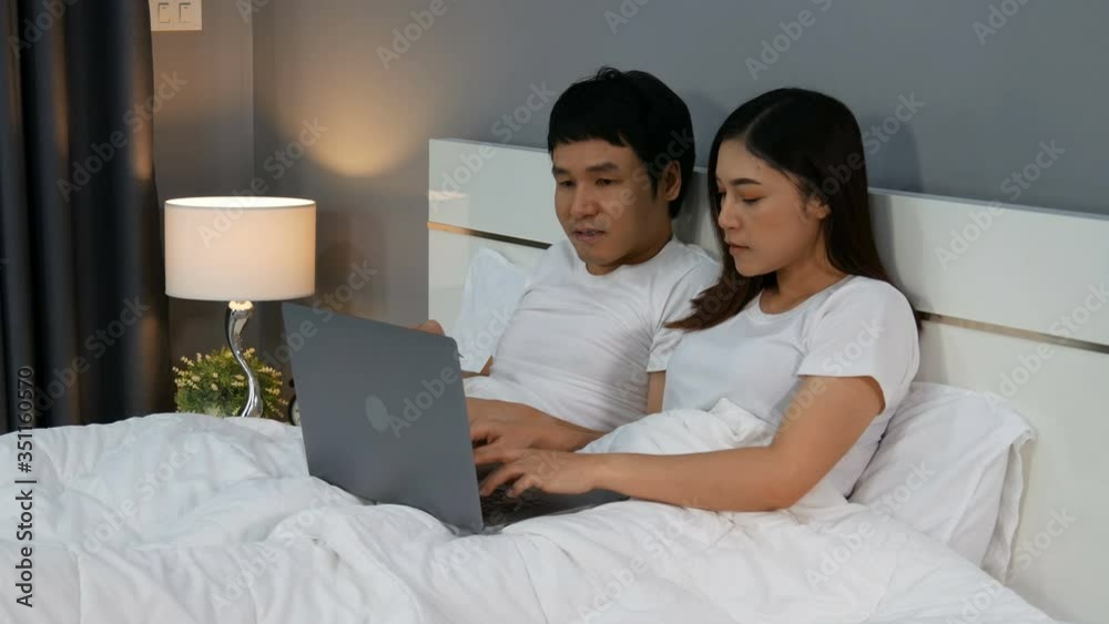 couple using laptop computer to shopping online with credit card on a bed. 4k video couple using laptop computer to shopping online with credit card on a bed. 4k video