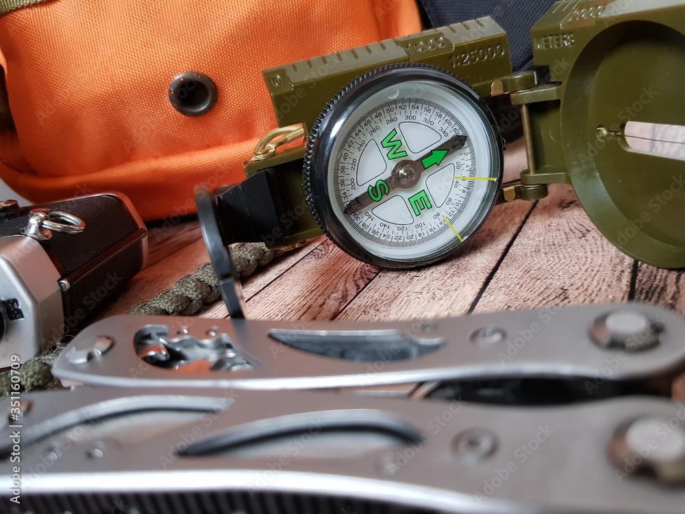 Fototapeta premium Compass, multitool and backpack for hiking