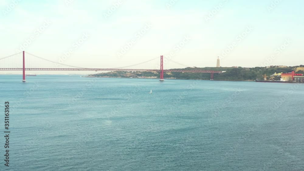 Boat sailing on the Tejo River in Lisbon with the bridge in backgroung, Portugal Boat sailing on the Tejo River in Lisbon with the bridge in backgroung, Portugal
