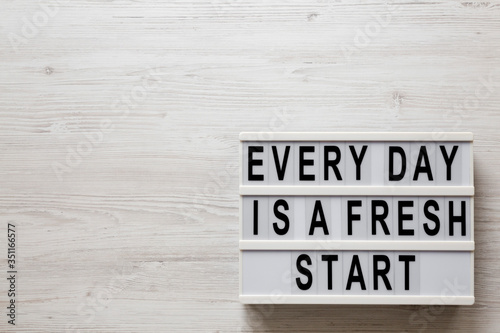 'Every day is a fresh start' words on a lightbox on a white wooden background, top view. Overhead, from above, flat lay. Copy space.