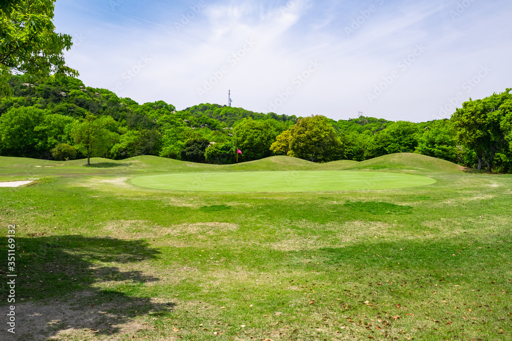 Fototapeta premium View of Golf Course with beautiful putting green. Golf course with a rich green turf beautiful scenery.