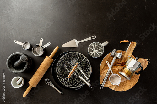 Kitchen utensils (cooking tools) on black background, free copy space