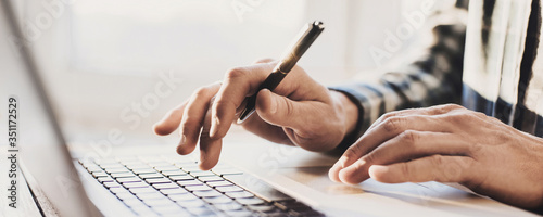 Fotografia Man hands typing on computer keyboard closeup, businessman or student using lapt
