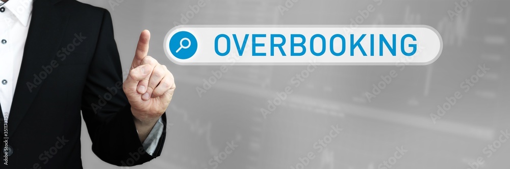 Overbooking. Businessman (Man) in a suit pointing with his finger to a search box. The word is in focus. Blue Background. Business, Finance, Statistics, Analysis, Economy Overbooking. Businessman (Man) in a suit pointing with his finger to a search box. The word is in focus. Blue Background. Business, Finance, Statistics, Analysis, Economy