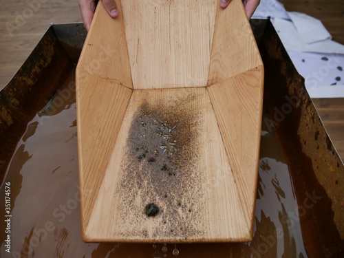 Search for gold nuggets in the gold-bearing rock in the old way using a wooden tray.
